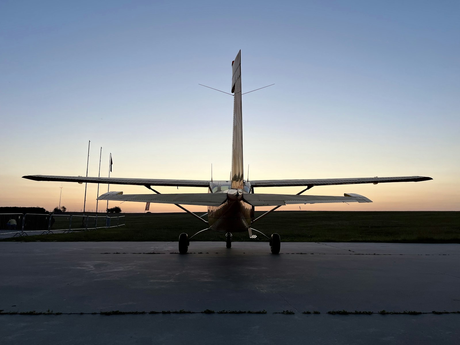 Light training aircraft parked on an airfield apron at sunset